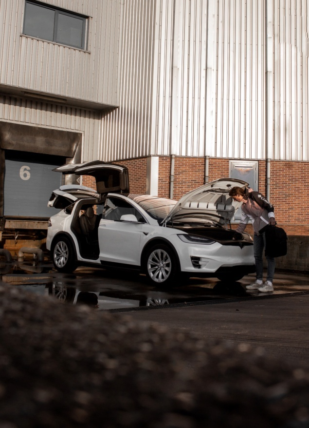  A woman looking inside the bonnet of a Tesla Model X