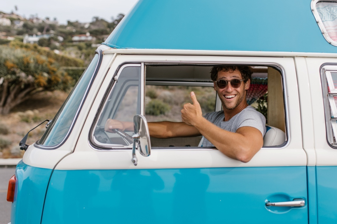 A man giving a thumbs up from his car window